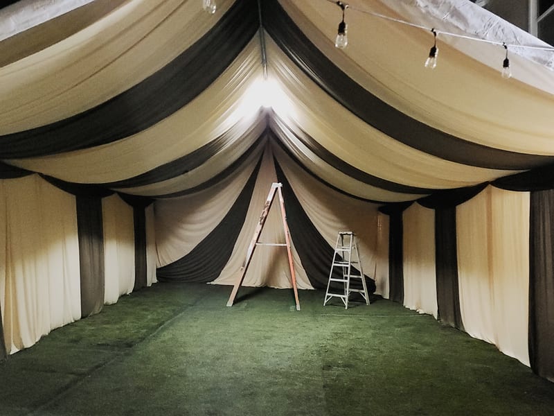 Elegant tent interior with draped fabric and linens