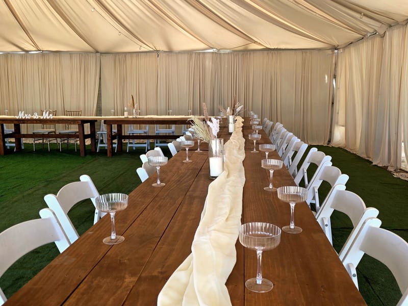 Wedding reception tent setup with draped tables